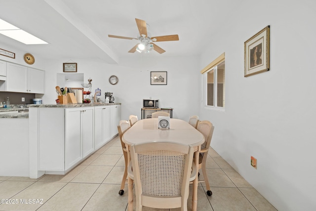 tiled dining space with ceiling fan