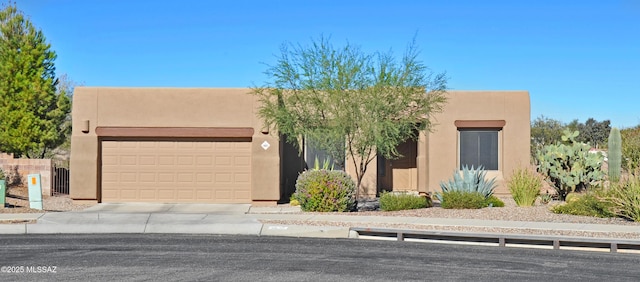 pueblo revival-style home with a garage