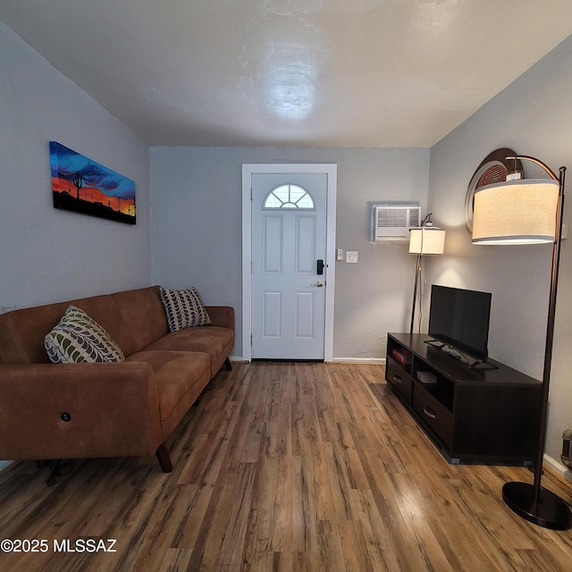 living room featuring hardwood / wood-style floors and a wall mounted air conditioner