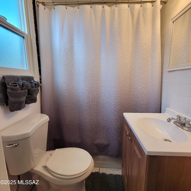 full bathroom featuring vanity, tile patterned floors, toilet, shower / bathtub combination with curtain, and tile walls