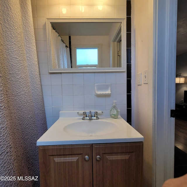 bathroom featuring vanity and tile walls