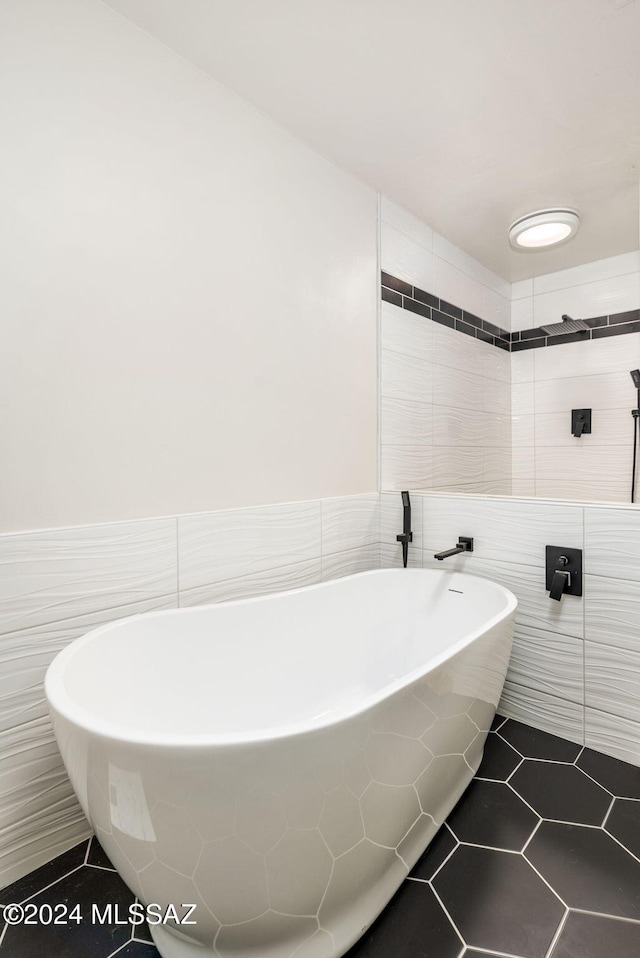 bathroom with tile patterned flooring, tile walls, and a tub