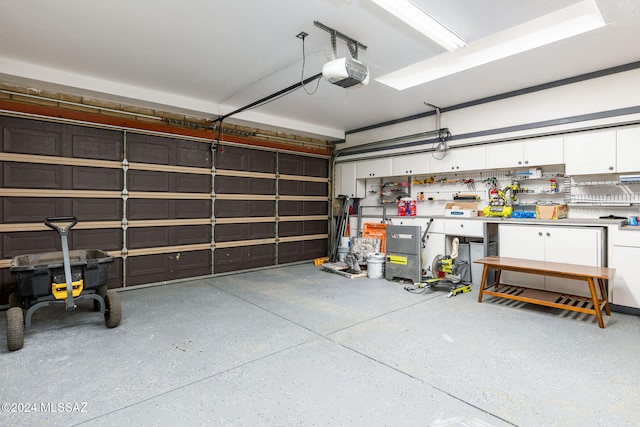 garage with a workshop area and a garage door opener