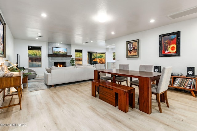 dining space with a large fireplace and light hardwood / wood-style floors