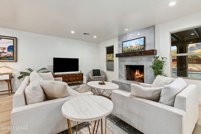 living room featuring light hardwood / wood-style floors, plenty of natural light, and a premium fireplace