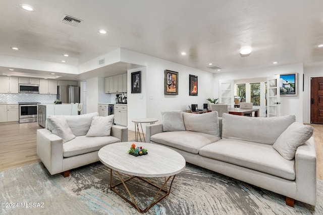 living room with light hardwood / wood-style flooring and french doors