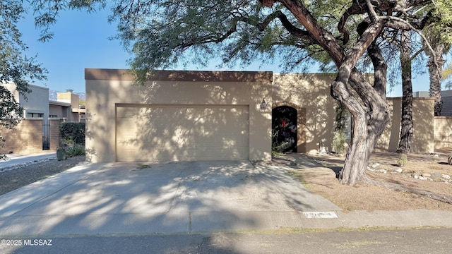 view of front facade with an attached garage, driveway, and stucco siding