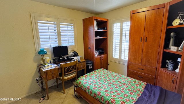 bedroom featuring multiple windows, baseboards, and light tile patterned floors