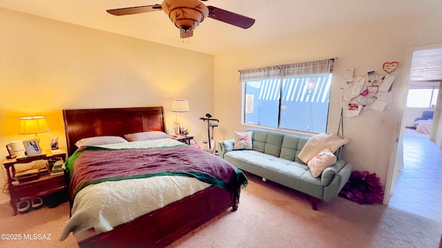 carpeted bedroom with tile patterned flooring and a ceiling fan