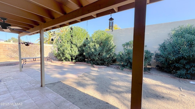 view of patio with fence and a ceiling fan