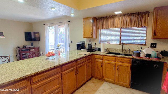 kitchen featuring light stone counters, black dishwasher, brown cabinetry, a sink, and a peninsula