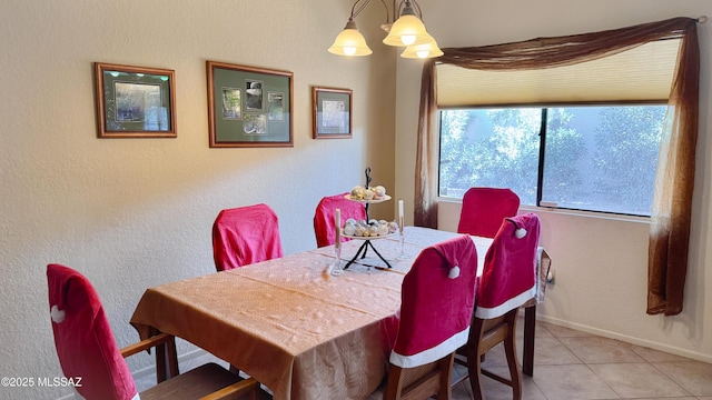 dining room featuring light tile patterned flooring, a notable chandelier, and baseboards