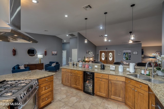 kitchen with sink, vaulted ceiling, beverage cooler, hanging light fixtures, and gas range