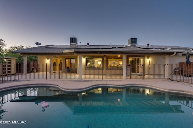 pool at dusk featuring a patio area