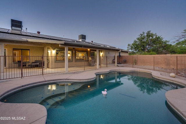 pool at dusk with a patio area and central AC unit