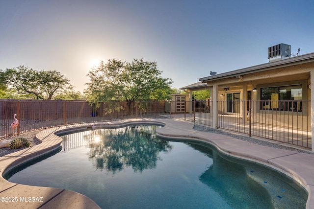 pool at dusk with a patio area and central AC unit