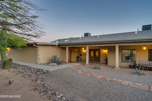 back house at dusk with a patio