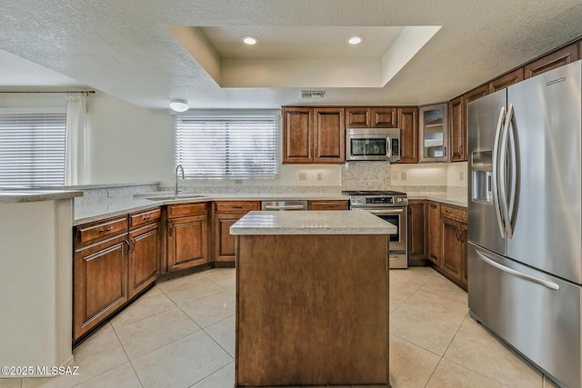 kitchen with visible vents, appliances with stainless steel finishes, a raised ceiling, and a sink