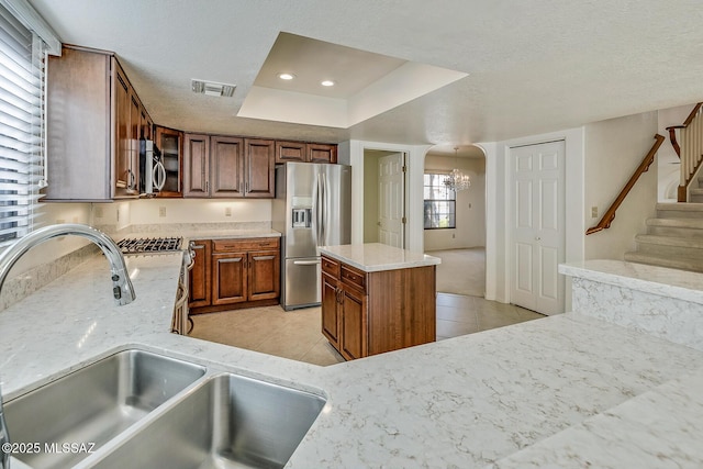 kitchen featuring visible vents, a sink, a textured ceiling, appliances with stainless steel finishes, and light tile patterned floors