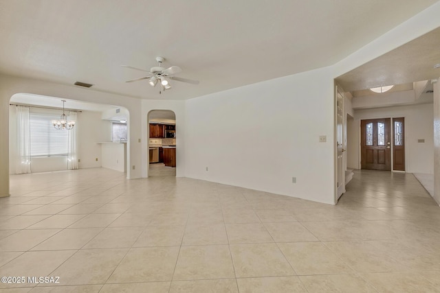 spare room with visible vents, light tile patterned floors, a ceiling fan, and arched walkways