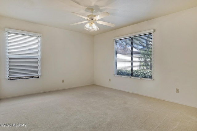 spare room with light colored carpet and ceiling fan