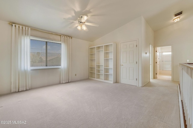 carpeted empty room featuring visible vents, ceiling fan, and vaulted ceiling