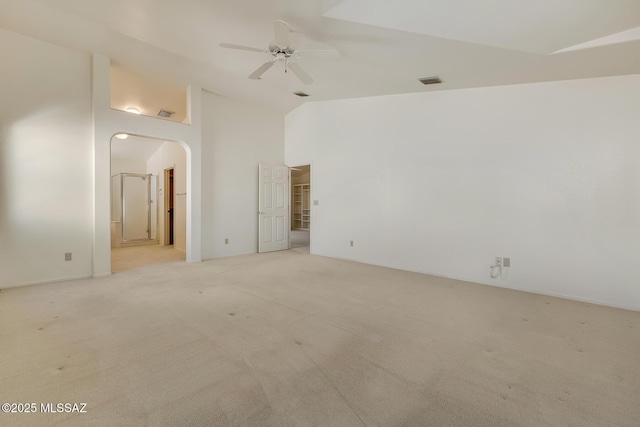 unfurnished room with visible vents, light carpet, high vaulted ceiling, a ceiling fan, and arched walkways