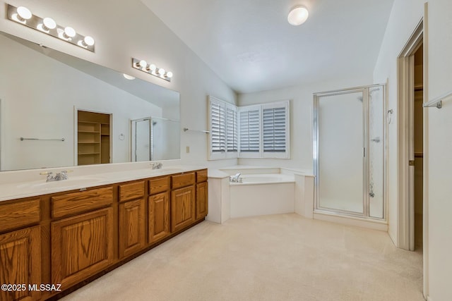 full bath featuring a shower stall, vaulted ceiling, double vanity, a bath, and a sink