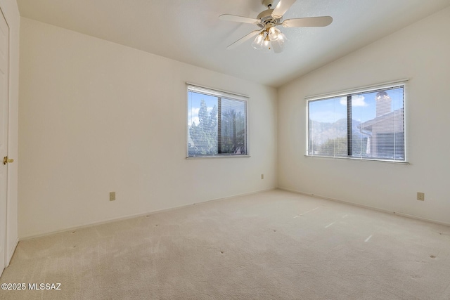 carpeted spare room featuring a ceiling fan and lofted ceiling