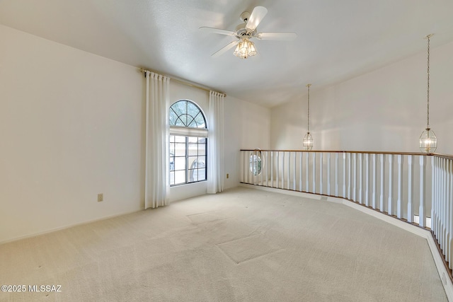 carpeted empty room featuring a high ceiling and a ceiling fan