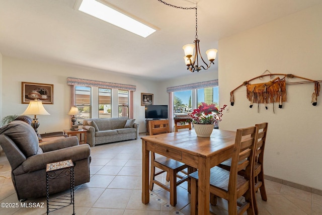 dining space featuring light tile patterned floors, plenty of natural light, and an inviting chandelier