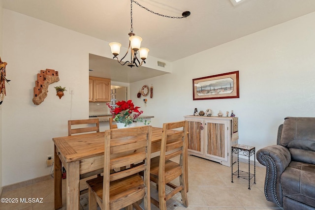 tiled dining space featuring a chandelier