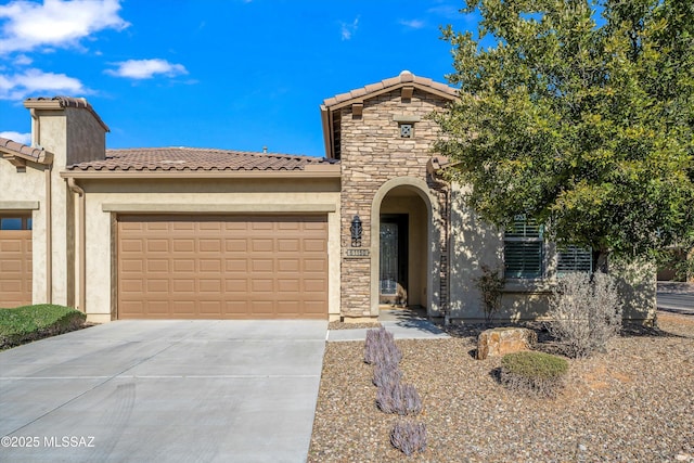 view of front of house with driveway, stone siding, an attached garage, and stucco siding