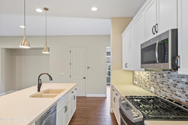 kitchen featuring tasteful backsplash, white cabinets, dark wood finished floors, stainless steel appliances, and a sink