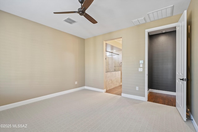 unfurnished bedroom featuring carpet, connected bathroom, visible vents, and baseboards