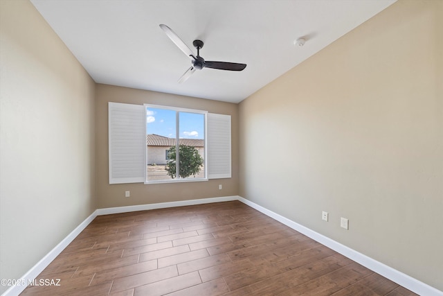 spare room with ceiling fan, wood finished floors, and baseboards