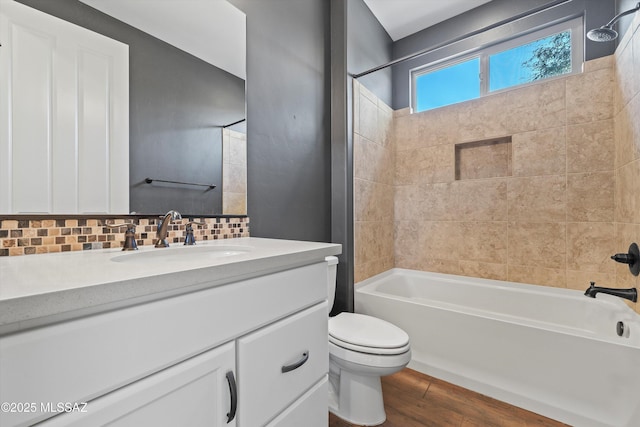 full bathroom with tasteful backsplash, toilet, shower / bathtub combination, wood finished floors, and vanity