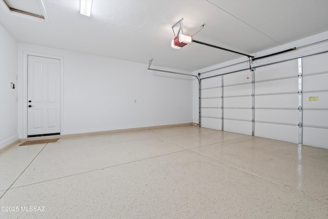 garage featuring a garage door opener and baseboards