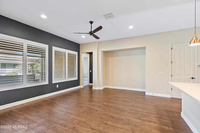 unfurnished room featuring ceiling fan, recessed lighting, wood finished floors, visible vents, and baseboards