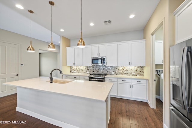 kitchen with visible vents, decorative backsplash, dark wood-style floors, appliances with stainless steel finishes, and a sink