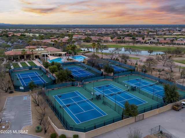 aerial view at dusk featuring a water view