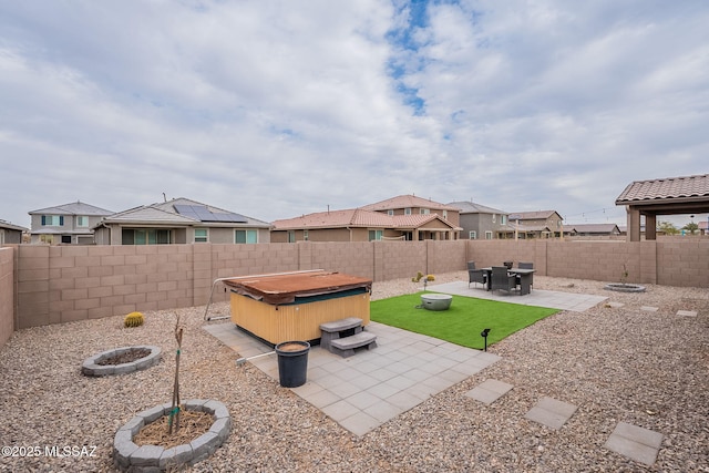 view of yard with a patio area, a hot tub, and an outdoor fire pit