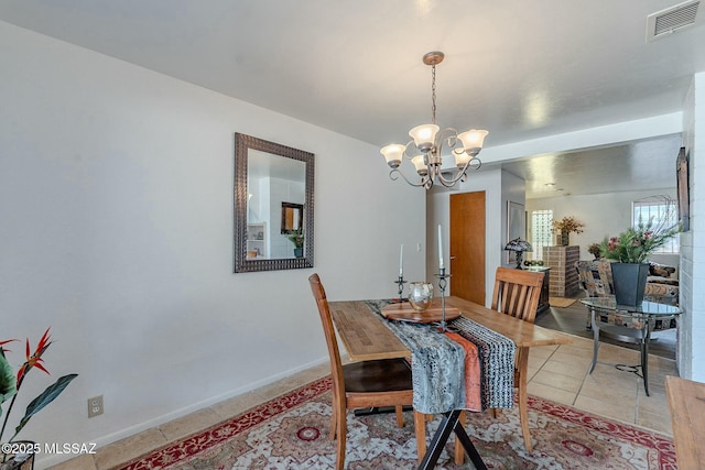 dining space with a notable chandelier and light tile patterned flooring