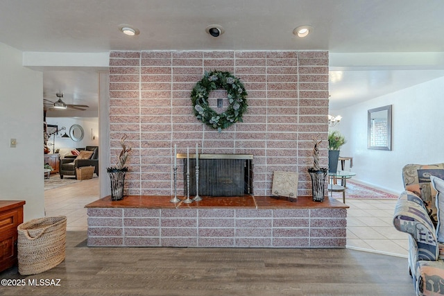 living room featuring hardwood / wood-style flooring, ceiling fan, and a fireplace