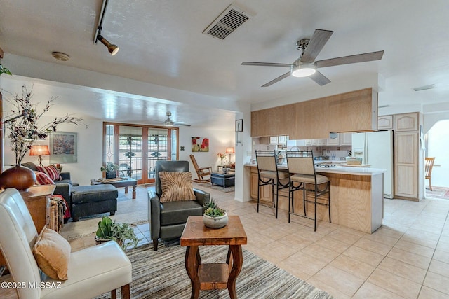 living room featuring light tile patterned floors, rail lighting, and ceiling fan