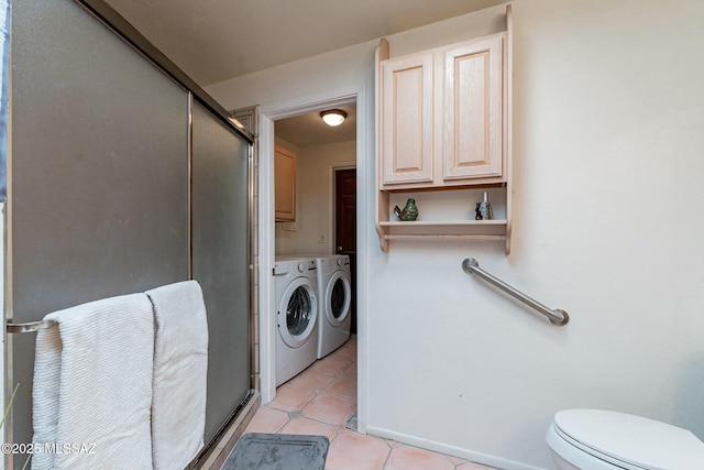 laundry area with light tile patterned floors and washing machine and clothes dryer