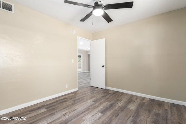 unfurnished room featuring ceiling fan and dark wood-type flooring