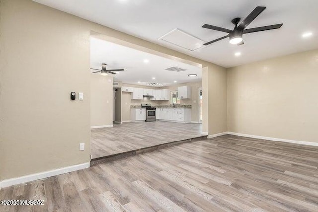 unfurnished living room with light wood-type flooring and ceiling fan