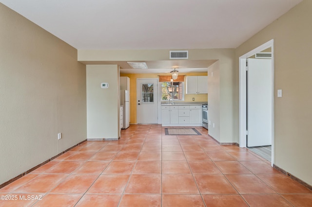 176 S Paseo Pena Unit C, Green Valley, AZ 85614 - interior space with visible vents, a sink, freestanding refrigerator, gas stove, and white cabinetry