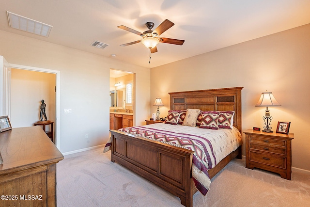 carpeted bedroom with ensuite bath and ceiling fan